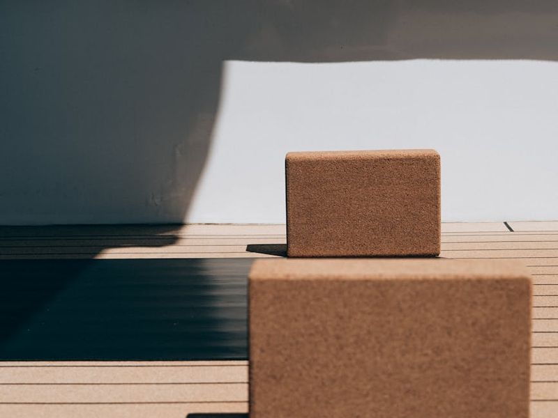 Elegant yoga mat and blocks on a wooden floor.